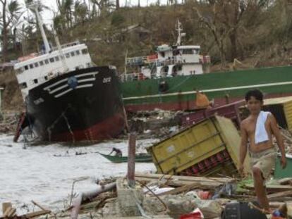 Dos filipinos se abren paso entre los escombros de Tacloban. 