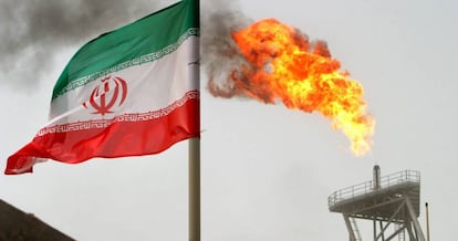 Una llamarada de gas en una plataforma petrol&iacute;fera de Soroush junto a una bandera iran&iacute;.