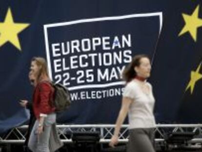 Varias personas caminan junto a la decoraci&oacute;n sobre las elecciones al Parlamento europea en Bruselas, B&eacute;lgica.