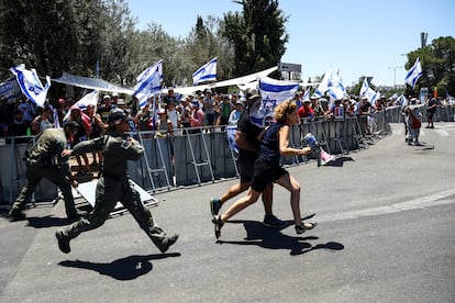 Manifestantes corren tras cruzar la línea policial a la entrada del Knesset, el Parlamento israelí, durante una manifestación contra la reforma judicial del primer ministro israelí, Benjamin Netanyahu, y su gobierno de coalición nacionalista, este lunes en Jerusalén.