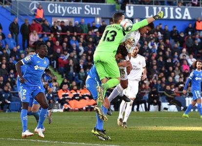 El defensa central del Real Madrid, Raphael Varane, bate por alto al portero del Getafe para anotar el primer gol del partido.