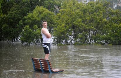 Según las previsiones el río Brisbane crecerá hasta 4 metros y medio a las tres de la tarde de mañana,  una marca que no supera la que se alcanzó en la crecida de 1974, un total de 5.45 metros. Un joven espera encima de un banco a ser rescatado tras el desbordamiento del río Brisbane.