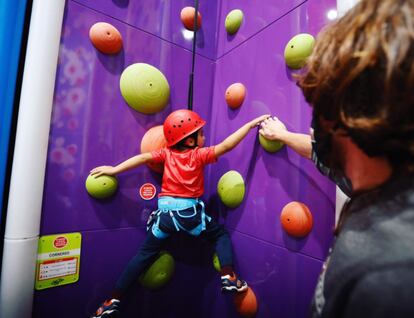 Un niño escala con ayuda de un monitor en el Climbat X-Madrid de Alcorcón, con casi 2.000 metros cuadrados para diferentes actividades y muros de escalada.