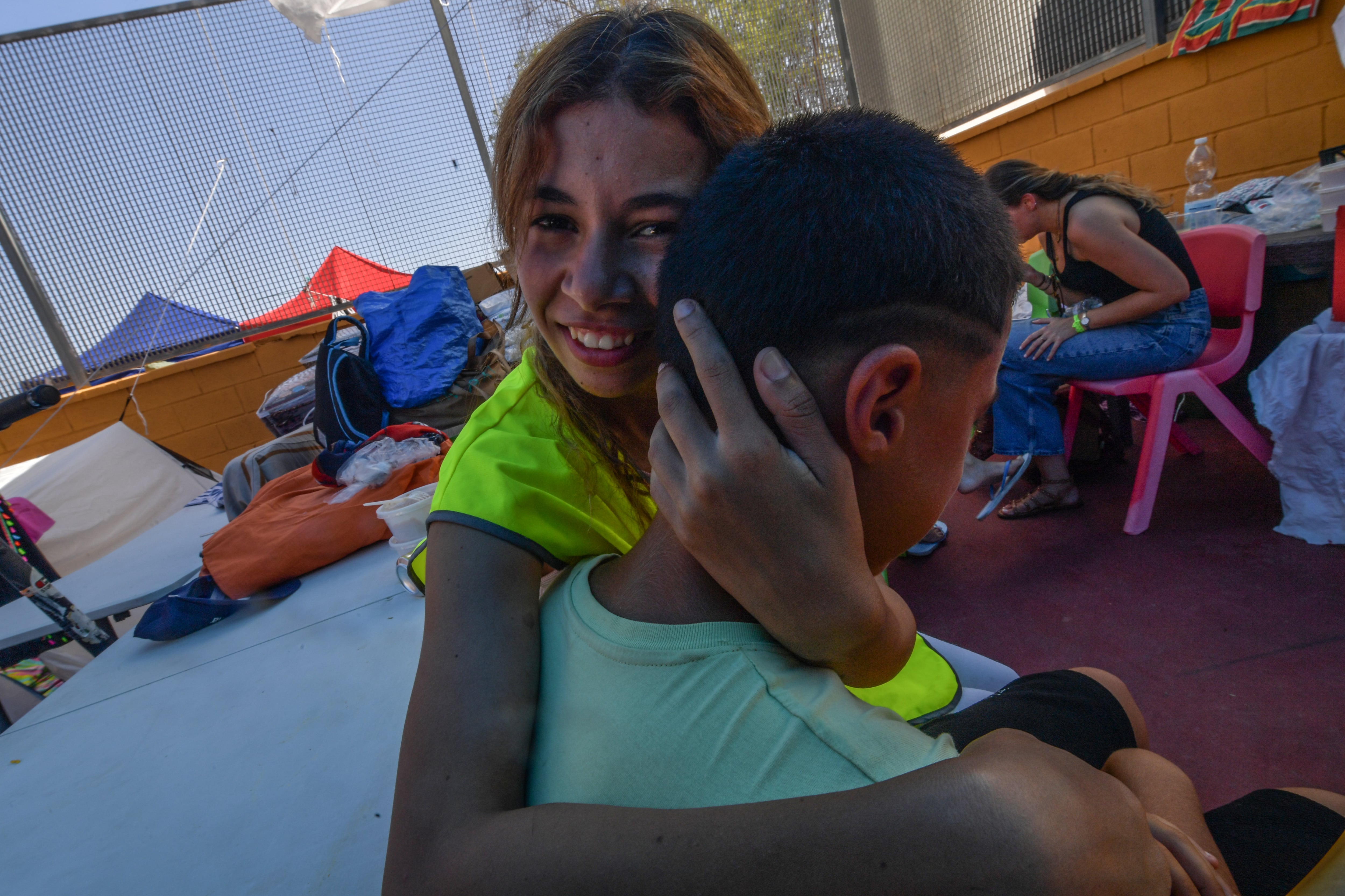 Una voluntaria argelina abraza a Ismail en el polideportivo de la barriada La Reina donde acogen a mujeres y niños.