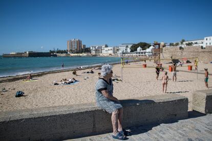 Una vecina sigue un partido de volley playa en La Caleta. 