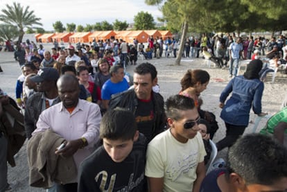 Decenas de vecinos hacen cola para pedir alojamiento y poder pasar la noche en el campamento de Huerto de la Rueda, en Lorca.