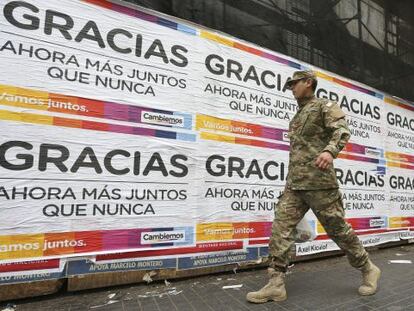Un uniformado pasa frente a los carteles de agradecimiento del candidato presidencial Mauricio Macri que aparecieron este lunes en Buenos Aires.