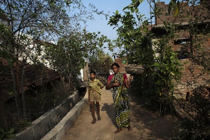 Una mujer y un niño caminan por una de las calles de Bodhali.