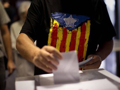 Un votante con la bandera independentista catalana deja su voto en Barcelona, en las elecciones del 27 de septiembre de 2015.
