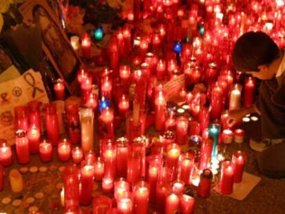 Un ni&ntilde;o enciende una vela en la estaci&oacute;n de cercan&iacute;as de El Pozo en memoria de las v&iacute;ctimas de los atentados contra los trenes del 11 de marzo en Madrid
