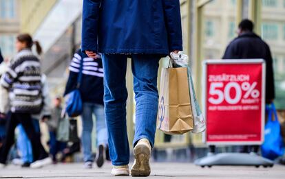 Un comprador con bolsas pasa por una calle de Berlín, este jueves.