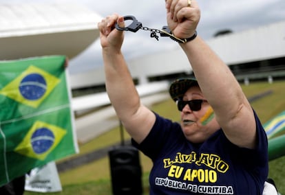 Un manifestante enseña unas esposas como protesta contra el expresidente brasileño Luiz Inácio Lula da Silva en Curitiba.