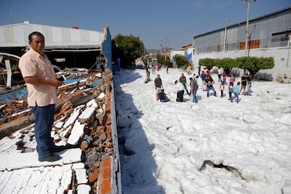 Los bomberos de Guadalajara y personal de Protección Civil de Jalisco trabajan en limpiar las toneladas de granizo y en la evaluación de los daños. En la imagen, un hombre junto a los escombros de un muro caído durante la tormenta.
