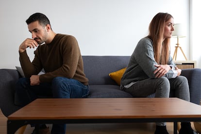 Una pareja joven sentada en un sofá.