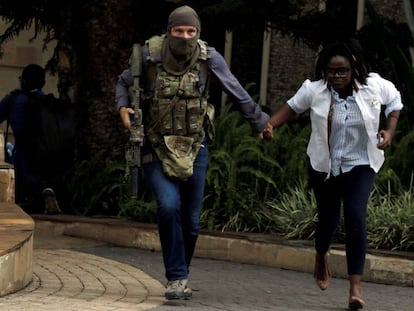 Un miembro de las fuerzas de seguridad kenianas evacúa a una mujer del hotel Dusit que fue atacado en Nairobi a mediados de enero.