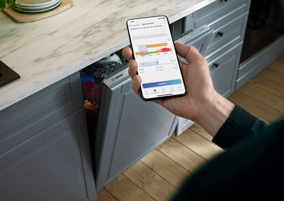 Un usuario programa el lavavajillas con una aplicación en el móvil.