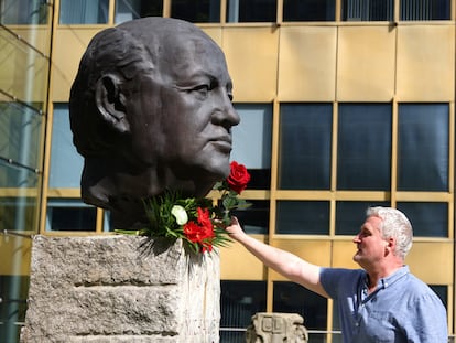 Un hombre deja una rosa en una escultura dedicada a Mijáil Gorbachov, en el monumento a los padres de la unificación, en Berlín, este miércoles.