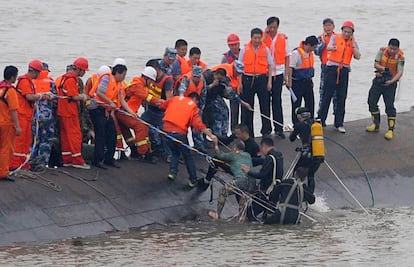 Un supervivent, amb samarreta verda, és rescatat pels equips de socors després del naufragi.