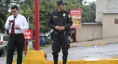 Un polic&iacute;a junto a un ciudadano en San Salvador