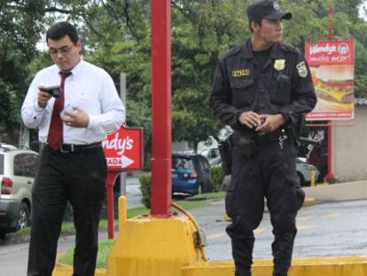 Un polic&iacute;a junto a un ciudadano en San Salvador