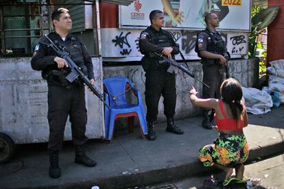 Una mujer que reside en la favela Alemão protesta frente a tres policías durante la redada.