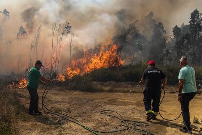 Varios bomberos trabajan por extinguir las llamas de un bosque en Soutelo, Portugal, este lunes.