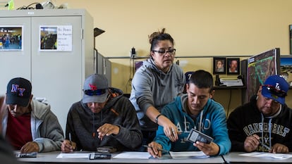 Mari Medrano, human resources director for CoCal Landscape, helps migrant workers complete paperwork in Denver in August 2017.