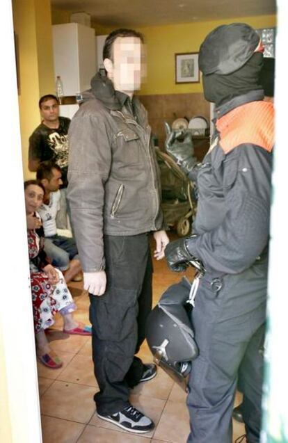 Agentes de los Mossos d' Esquadra custodian en una vivienda a algunas de las 50 personas que han sido detenidas durante una operación policial en el distrito de Sant Martí de Barcelona contra una banda dedicada al robo de cobre y a su comercialización.