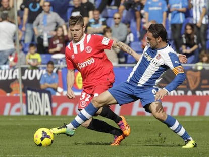 El delantero del RCD Espanyol, Sergio Garcia (d), intenta controlar el balón ante el defensa del Sevilla CF , Alberto Moreno (i), durante el partido de liga correspondiente a la 13 jornada disputado hoy en el estadio de Cornellà-El Prat.