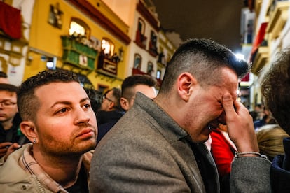 Un hombre llora ante la entrada de la capilla de Los Marineros, en la que se encuentra La Virgen de la Esperanza de Triana, donde miles de fieles se han concentrado para verla al conocer que no saldrá en estación de penitencia esta madrugá debido al temporal de lluvia. 
