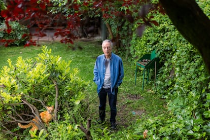 Juan José Millás posa en el jardín de su casa (por donde pulula su gato Misu), el 15 de mayo de 2025. 