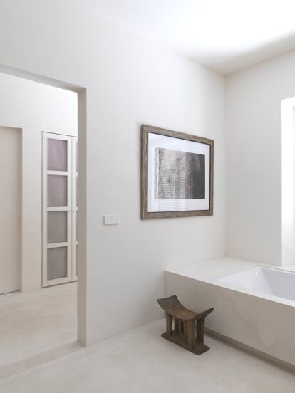 En el baño, completamente blanco, la bañera es un diseño producido por la empresa Duravit. El taburete es africano.