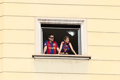 Dos aficionados observan el paso del vehículo que lleva a los jugadores.