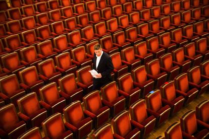 Un acomodador camina entre los asientos antes de la llegada de los invitados a la ópera Semperoper, durante las celebraciones del Día de la Unidad Alemana, en Desde.