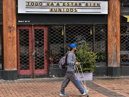 Un transeúnte pasa frente a un restaurante cerrado con un letrero que dice "todo estará bien", en Bogotá, el 2 de julio de 2020.