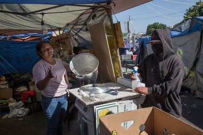 Mientras una fila de personas espera su desayuno, María Elena anuncia que la avena se acabó. Muchas familias solo comen lo que reparten en la única cocina del campamento.