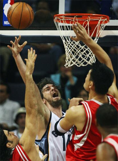 Gasol intenta una canasta ante los jugadores de los Rockets Yao Ming y Scola