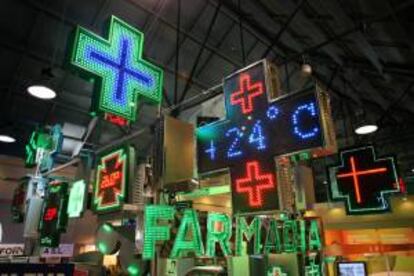 Diferentes logotipos luminosos de farmacias se muestran en un stand en el XV Congreso Nacional Farmacéutico. EFE/Archivo