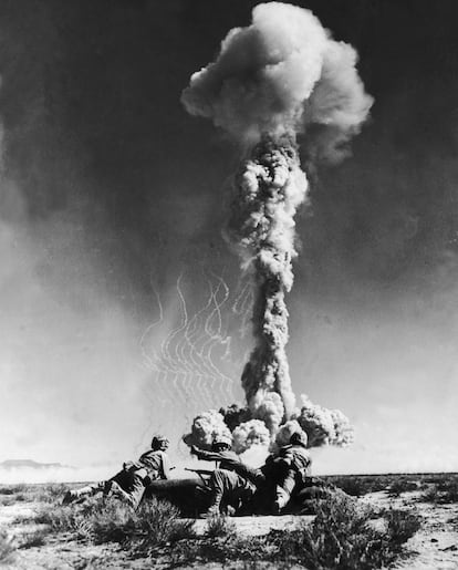 Tres soldados estadounidenses observan la explosión de una bomba atómica, en el desierto de Nevada en torno a 1950.