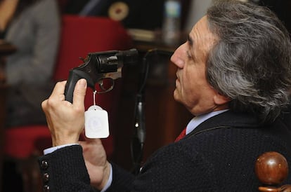 A police officer with the murder weapon during the trial.