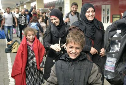 Una familia de refugiados sonríe al llegar a Viena tras un periplo a través de Hungría y otros países huyendo de la guerra.