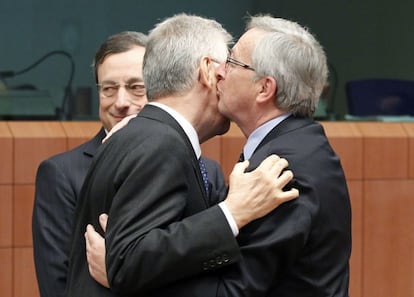 Jean-Claude Juncker, presidente del Eurogrupo (derecha), saluda al ministro de Economía italiano Mario Monti en presencia del presidente del BCE, Mario Draghi.