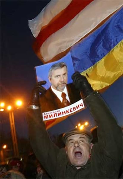Un partidario de Milinkevich muestra un cartel con la efigie del líder opositor.