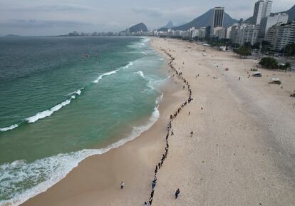 La gente formaba una fila el miércoles a lo largo de la playa de Copacabana para un abrazo grupal simbólico con el mar en el Día Mundial de los Océanos, en Río de Janeiro (Brasil). La organización Route Brasil convocó a la gente a reunirse para el evento y para recoger basura de la playa.