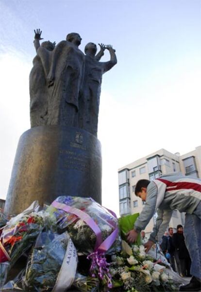 En el segundo aniversario del atentado terrorista del 11 de marzo en Madrid, que segó la vida de 191 personas, se han sucedido los homenajes institucionales y ciudadanos. En la imagen, vecinos de Torrejón de Ardoz colocan flores en la estatua que rememora la tragedia en esta ciudad madrileña.