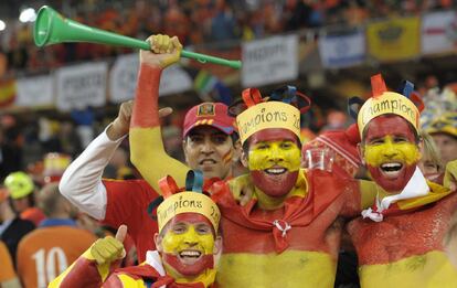 Tres aficionados pintados de la cabeza a los pies con los colores de la roja en el estadio donde se disputa la final del Mundial, el Soccer City de Johanesburgo.