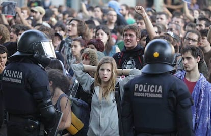 Agentes de la Policía Nacional mantienen un cerco de seguridad ante las protestas de los manifestantes concentrados ante la sede del Parlament, en Barcelona.