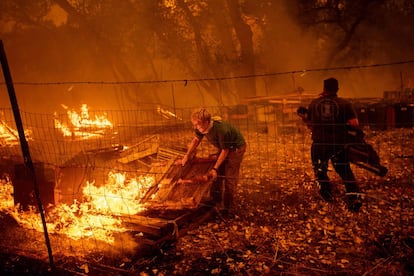 Morador carrega paletes de madeira para proteger sua casa em Clearlake Oaks, em 4 de agosto de 2018.