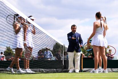 El árbitro habla con Katy Dunne y Harriet Dart de Gran Bretaña, y con Hao-Ching Chan y Latisha Chan de Taiwán en su partido de primera ronda de dobles de damas durante el tercer día del Campeonato.