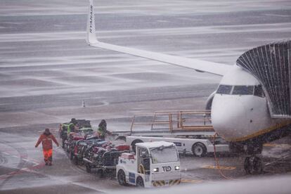 Varios operarios trabajan durante la jornada de nieve en una de las pistas del aeropuerto de Barajas, el 5 de febrero de 2018.